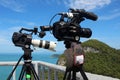 Video camera on a tripod on top of the mountain. Ocean and blue Royalty Free Stock Photo