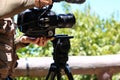 Videographer holding the video camera on a tripod on top of the Royalty Free Stock Photo