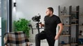 Videographer man with camera mounted on gimbal stabilizer equipment indoors. Royalty Free Stock Photo