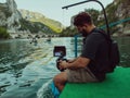 A videographer recording a group of friends kayaking together and exploring river canyons