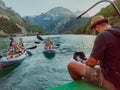 A videographer recording a group of friends kayaking together and exploring river canyons