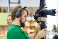 Videographer shooting a film or a television program in a studio with a professional camera, backstage