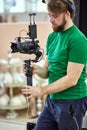 Videographer shooting a film or a television program in a studio with a professional camera, backstage Royalty Free Stock Photo