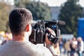 videographer shoots a report on a camera on a city street