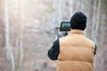 Man with videocamera filming forest in autumn