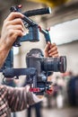 Videographer using stadicam, making video of machine at factory