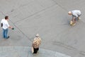 male couple go for a walk with their small dog. They teach hin crossing the street and an old lady watches the scene