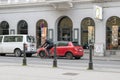 pedaling past a cyclist overtakes a red car on a vienna street