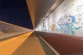 Pedestrians walk and cyclists ride on the bridge at night