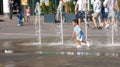 Children frolic in the jets of the city fountain in the summer heat