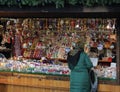 VIENNA, AUSTRIA DECEMBER 9, 2014: A girl in a Russian scarf and a green down jacket chooses Christmas tree toys at the Christmas