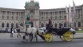 VIENNA, AUSTRIA - DECEMBER, 24 Retro horse-drawn carriage against Austrian National Library on Heldenplatz. Popular