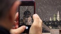 Vienna, snowing Fragment picture appears on tablet, smartphone in man`s hands. Blurred background