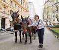 Vienna, Austria. Girl tourist stroking horses in a carriage.