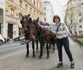 Vienna, Austria. Girl tourist stroking horses in a carriage.
