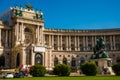 Vienna, Austria: Hofburg palace and panoramic square view, people walking and fiaker with white horses in Vienna, Austria Royalty Free Stock Photo