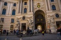 Vienna, Austria: Hofburg palace and panoramic square view, people walking and fiaker with white horses in Vienna, Austria Royalty Free Stock Photo