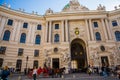 Vienna, Austria: Hofburg palace and panoramic square view, people walking and fiaker with white horses in Vienna, Austria Royalty Free Stock Photo