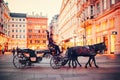 Vienna, Austria. Horse and carriage ridding on the streets of Vienna in the evening. Royalty Free Stock Photo