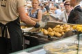 Vienna / Austria - 31 July 2019: Chef frying potatoes in october fest in Vienna, Austria, with gloves. Austrian customer waiting