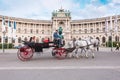 Hofburg Palace and Heldenplatz with a passing carriage with a pair of horses, Vienna, Austria Royalty Free Stock Photo