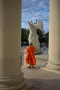 A Buddhist monk stands at the entrance to the Karlskirche church on Karlsplatz square.