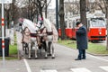 Traditional Coachman and two white decorated horses, called Fiaker, waiting for tourists at