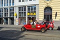 VIENNA, AUSTRIA - OKTOBER 13, 2018: Tourists drive a vintage red car without a roof on a street in Vienna