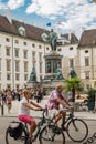 Vienna, Austria - September , 15, 2019: Biker couple in front of the monument to Francis II in a courtyard surrounded of