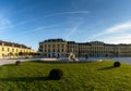 View of the front of the historic Schoenbrunn Palace in Vienna in warm evening light with a fountain in the foreground