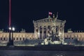 Austrian parliament building illuminated, at night, with the Austrian flag waving. Royalty Free Stock Photo