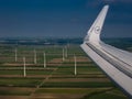 Vienna - June 1 2019: wing of a Lufthansa airplane landing with a wind generators farm