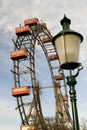 Vienna prater park amusement giant wheel with red cabins. from ground with a blurred street lamp Royalty Free Stock Photo