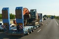 A large truck is driving along the highway, carrying a cylindrical load.