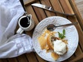 Viennese apple strudel with a scoop of vanilla ice cream, mint on a white glass plate, next to a white gravy boat with syrup Royalty Free Stock Photo