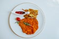 Viennese Schnitzel with fried potatoes, rosemary and ketchup on white plate Royalty Free Stock Photo