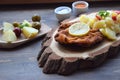 Viennese schnitzel on a wooden board with lemon on a dark background. Meat dish.