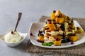 Viennese waffles with ice cream and slices of mango doused with chocolate,in a white plate on a gray background Royalty Free Stock Photo