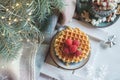 Viennese waffles with raspberries and honey on the christmas table with christmas tree branches and garlands of lights in the Royalty Free Stock Photo