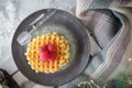 Viennese waffles with raspberries and honey on the christmas table with christmas tree branches and garlands of lights in the Royalty Free Stock Photo