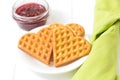 Viennese waffles, raspberry jam in a glass bowl on a white background