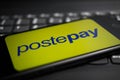 Viersen, Germany - April 9. 2020: Close up of mobile phone screen with logo lettering of postepay payment provider on computer