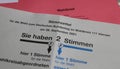 Closeup of german ballot paper for postal voting with red pencil and envelopes