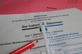 Closeup of german ballot paper for postal voting with red pencil and envelopes