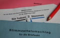 Closeup of german ballot paper for postal voting with red pencil and envelopes