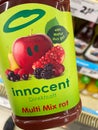 View on hand holding bottle innocent multivitamin fruit juice in german supermarket