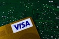Internet and online payment security concept: Golden Visa credit card on green computer circuit board