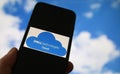 Closeup of smartphone with logo lettering of cloud computing provider service dell technologies, blurred sky and cloud background