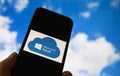 Closeup of smartphone with logo lettering of cloud computing provider service microsoft azure, blurred sky and cloud background