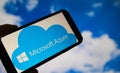 Closeup of smartphone with logo lettering of cloud computing provider service microsoft azure, blurred sky and cloud background